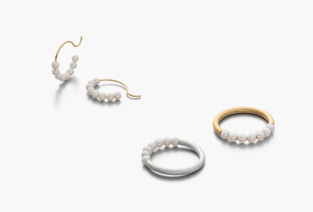 Hoop earrings and rings from the <em>Pin</em> series. Freshwater pearls, rhodium-plated silver, 750 gold.