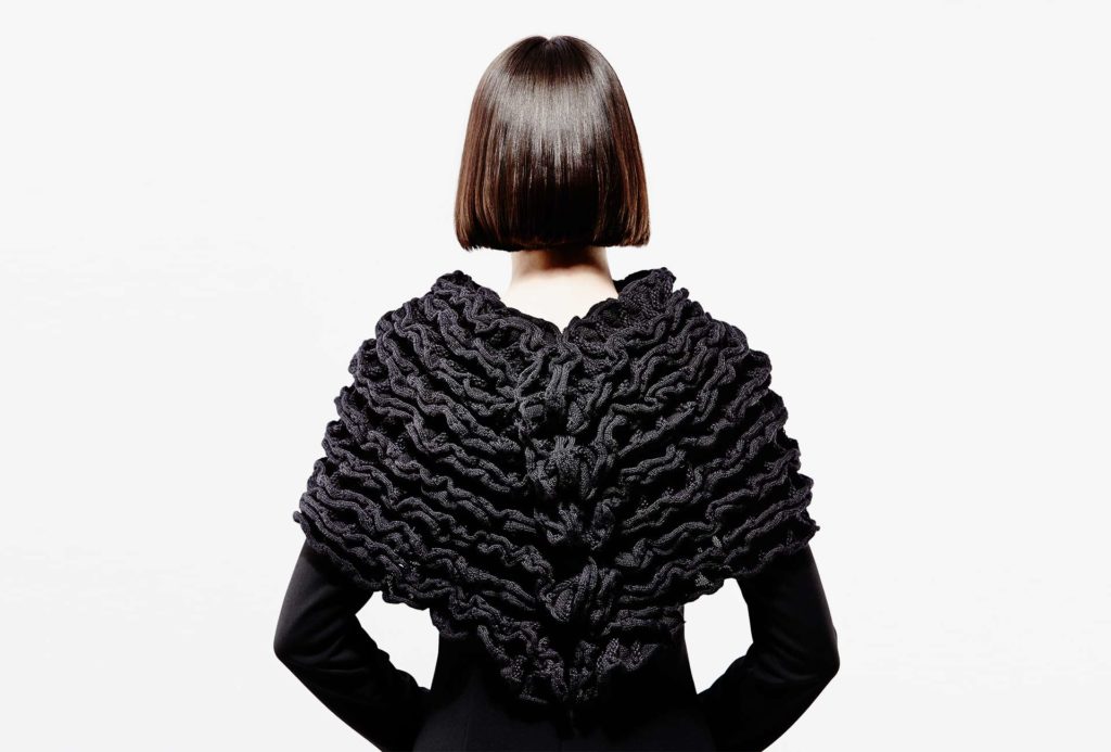 <em>ALINEA</em>, black, 2016, knit cape. 70% merino extrafine, 20% silk, 10% cashmere, width 65cm, height 40cm. Photo Ingo Misiak.