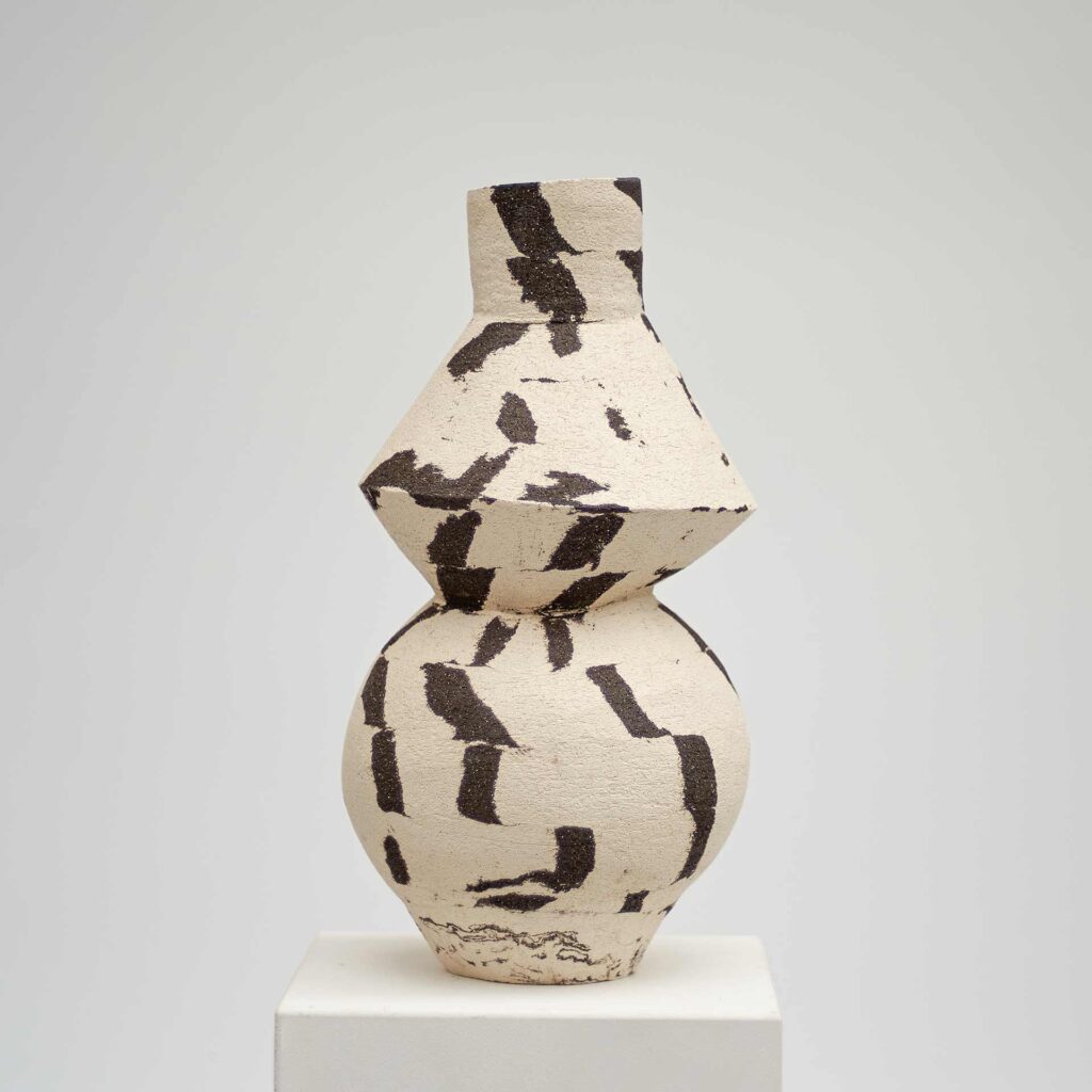 <em>DUOTONE</em> vase, black and white, with a round base and geometric shape above, 17 x 16 x 33 cm.